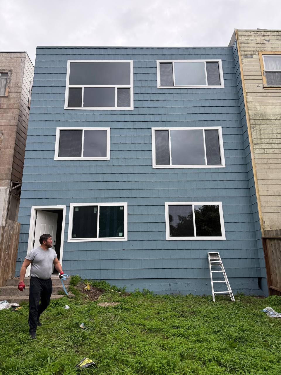 Blue siding home with newly installed white windows